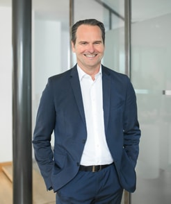 Stefan Schneider, Geschäftsführer der Schneider Immobilien GmbH steht im modernen Foyer des Büros auf der Bahnstraße 1 in Ratingen
