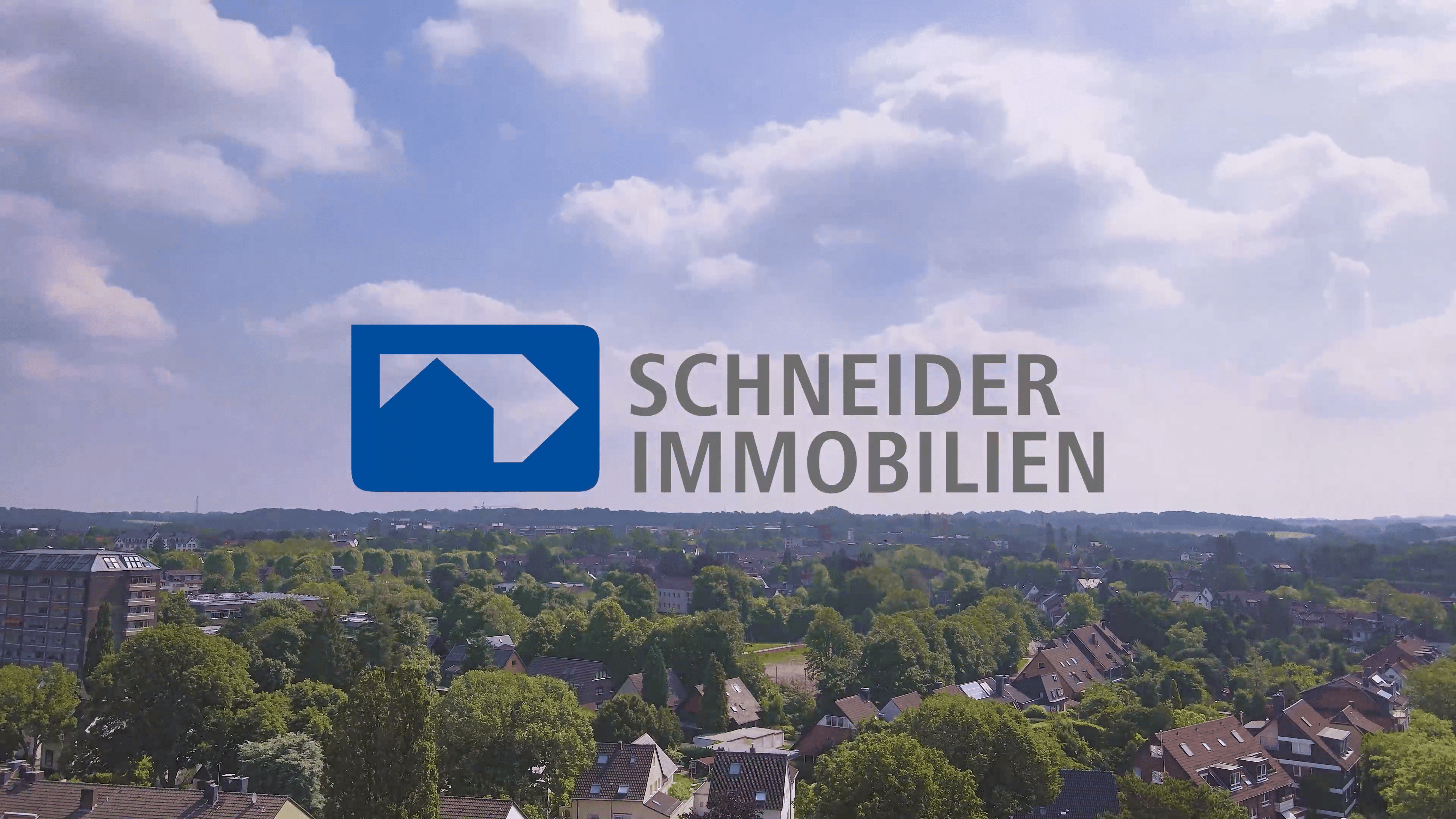 Das Logo von Schneider Immobilien über den Dächern von Ratingen